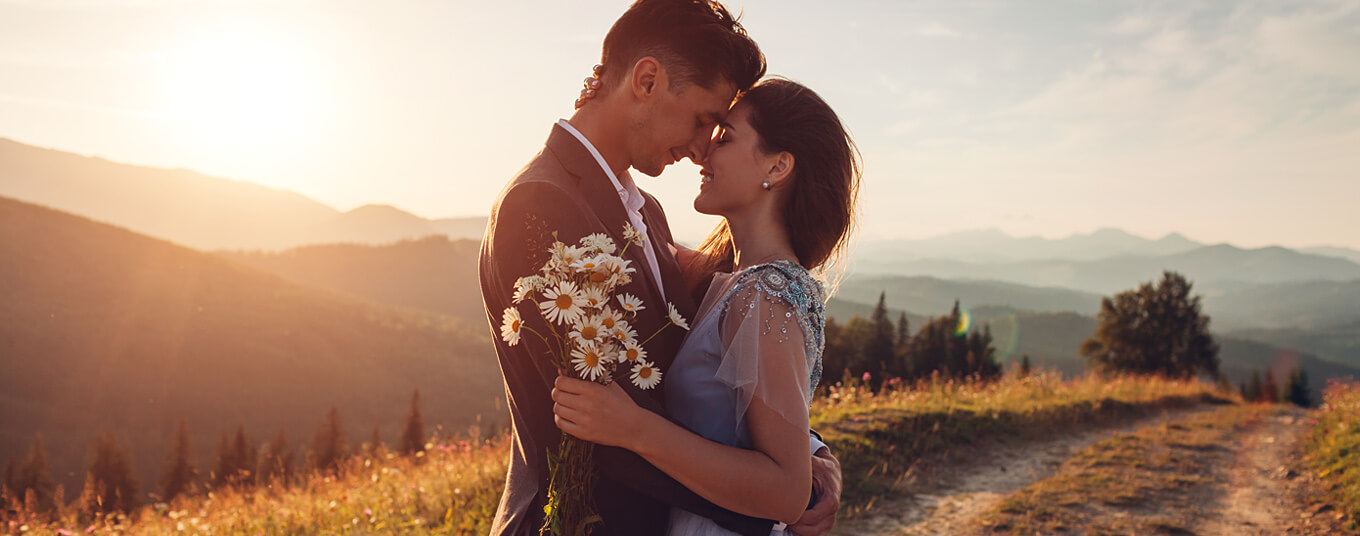 couple eloping in the mountain holding daisies